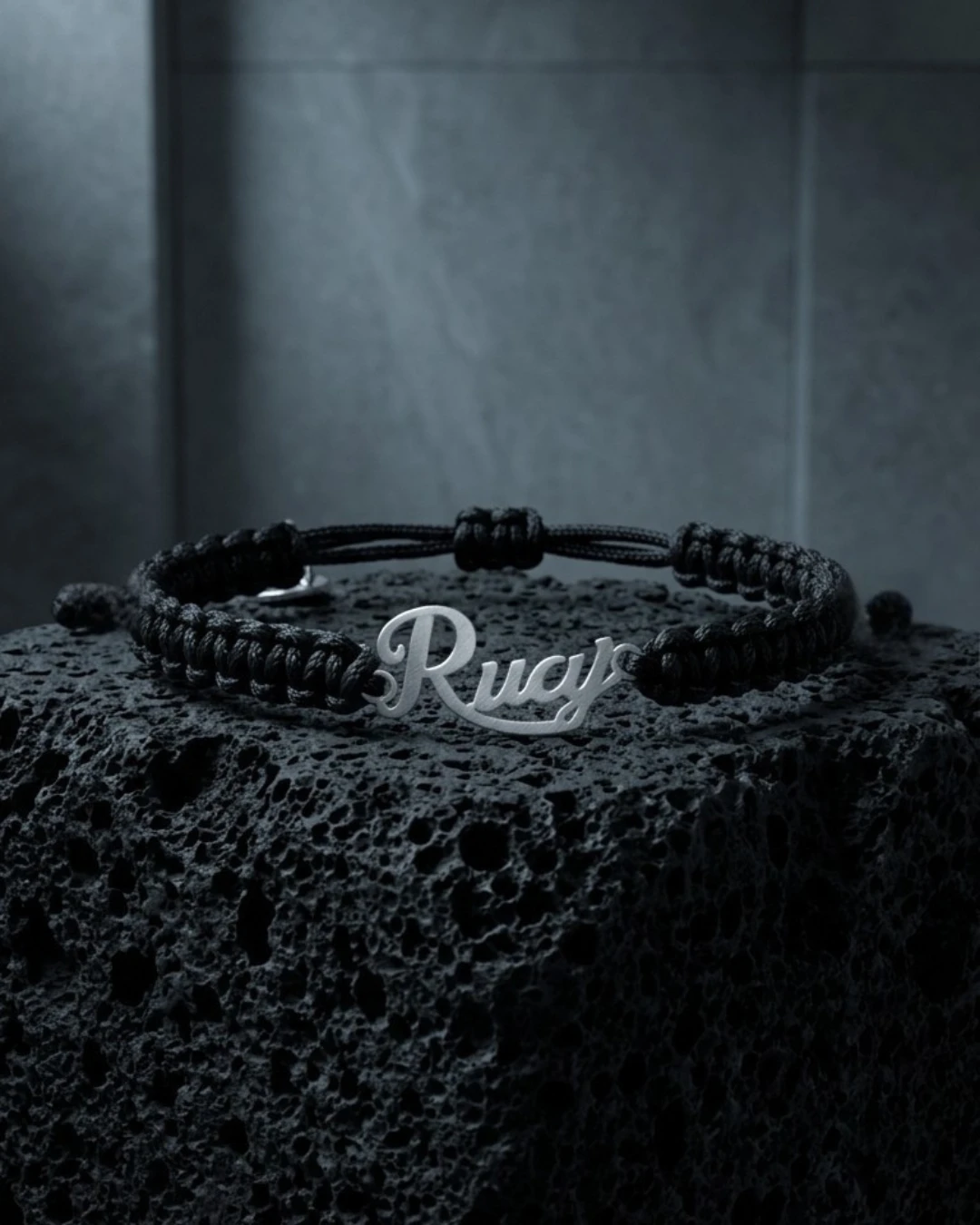 Detalle de la pulsera RUAJ en plata sobre roca volcánica oscura